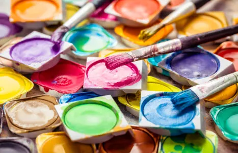 Colors and brushes on wooden background