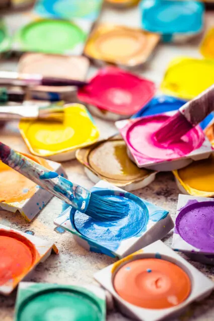 Colors and brushes on wooden background