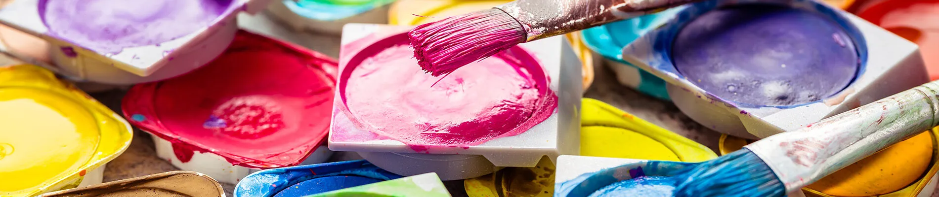 Colors and brushes on wooden background